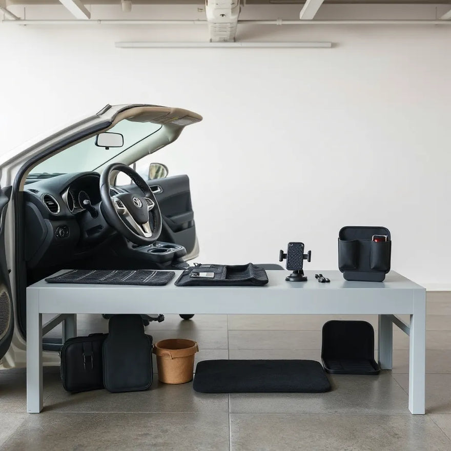 Assorted car accessories arranged beside an open car door, including mats, organizer, and a phone mount